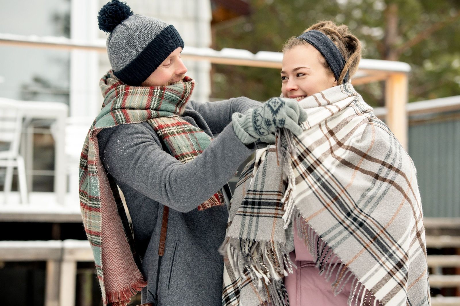 Pareja envuelta en mantas disfrutando de un día de invierno al aire libre